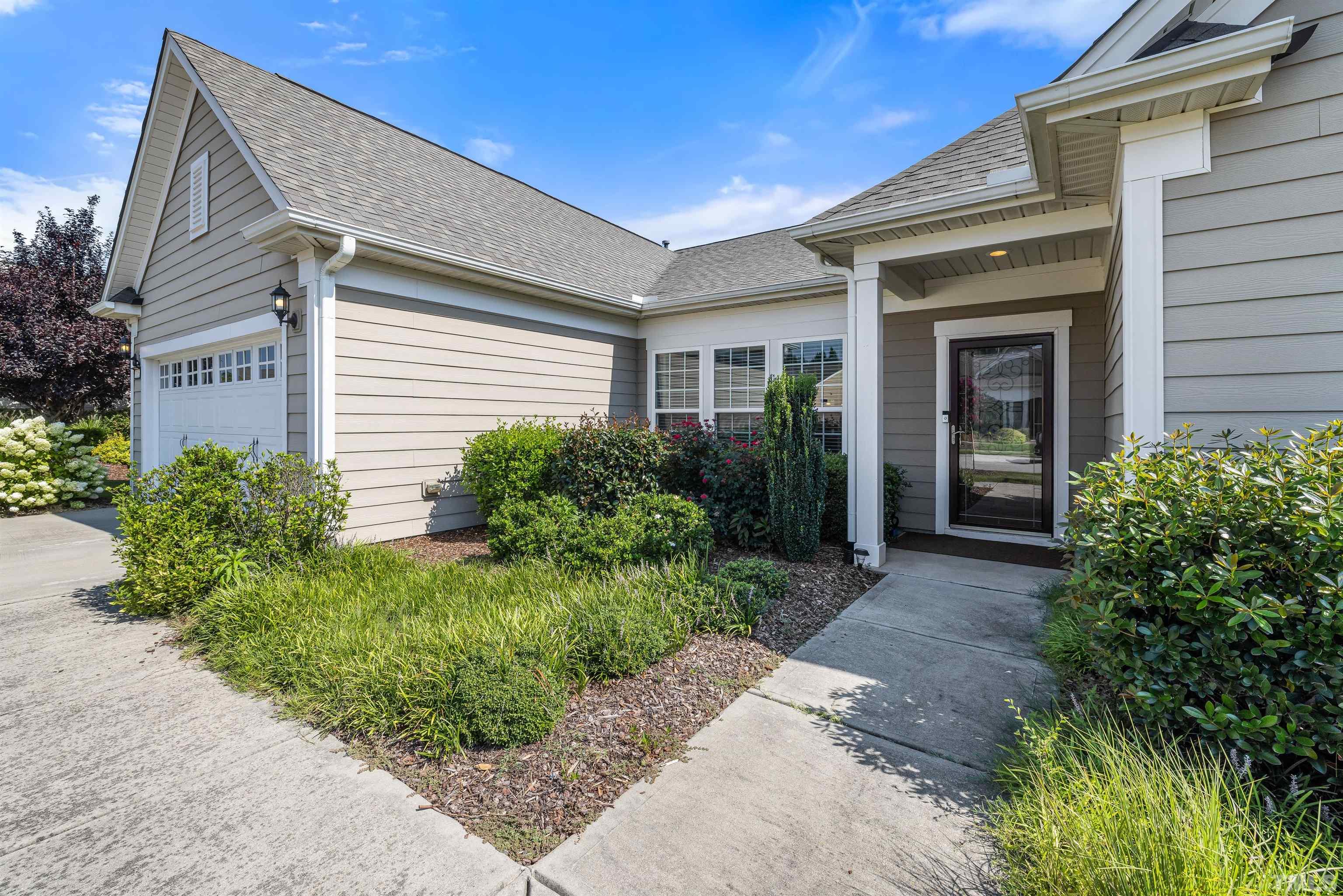 1115 Hooper Place Durham, NC 27703 - Photo 36 of 40 a view of a brick house with potted plants and a large window