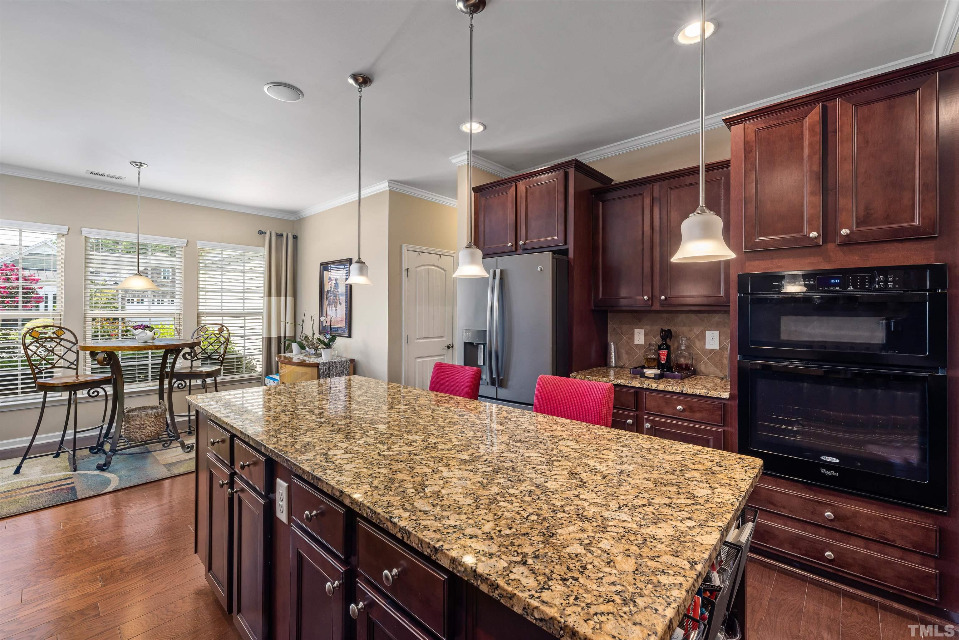 1115 Hooper Place Durham, NC 27703 - Photo 6 of 40 a kitchen with granite countertop lots of wooden cabinets stainless steel appliances and a center island