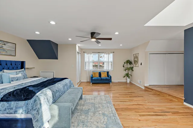 a large bedroom with bed and a large window