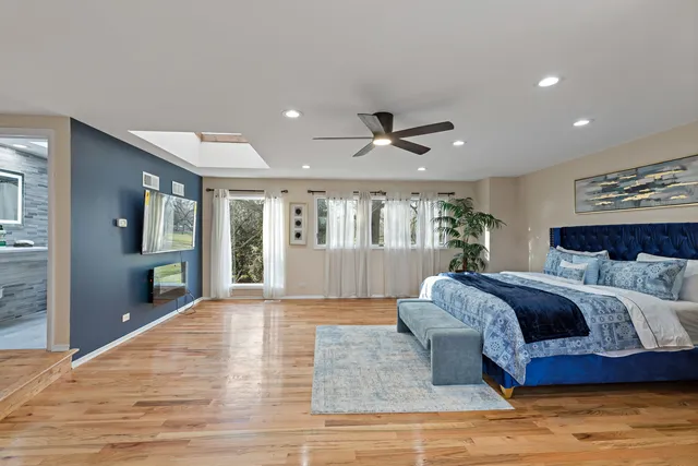 a spacious bedroom with a large bed chandelier and a window