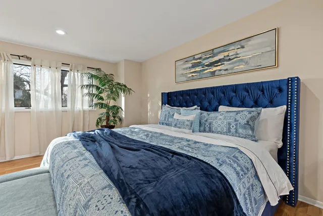 a bedroom with a large bed and a potted plant