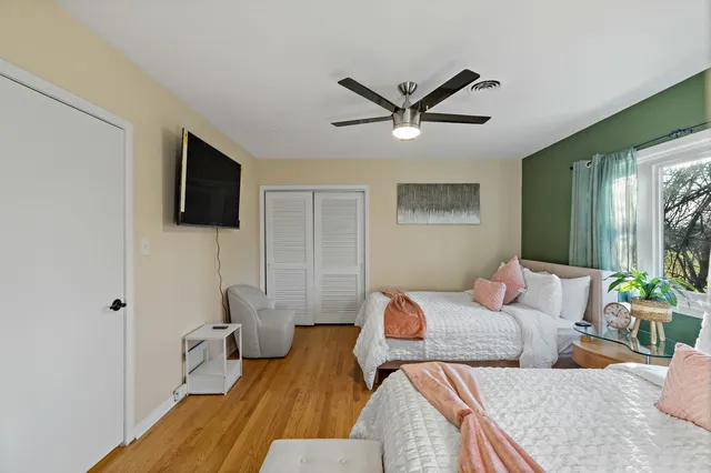 a bedroom with two beds and a flat screen tv