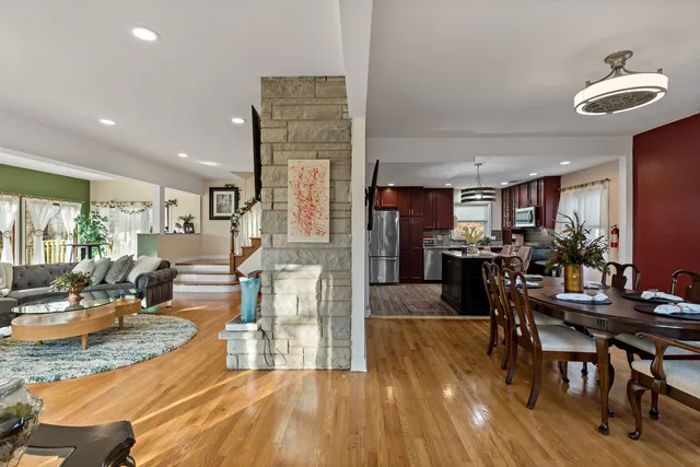 a view of a dining room and livingroom with furniture wooden floor a chandelier