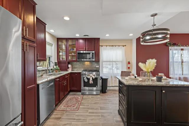 a kitchen with stainless steel appliances granite countertop a sink refrigerator and cabinets