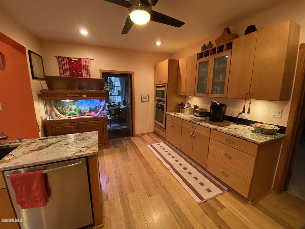 2871 West Forest Road Freeport, IL 61032 - Photo 35 of 68 a kitchen with stainless steel appliances kitchen island granite countertop a sink stove and wooden floor