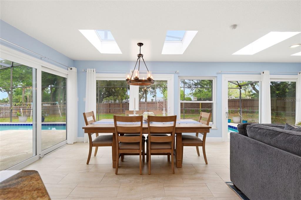 7432 Sparkling Lake Road Orlando, FL 32819 - Photo 16 of 54 a view of a dining room with furniture large windows and wooden floor