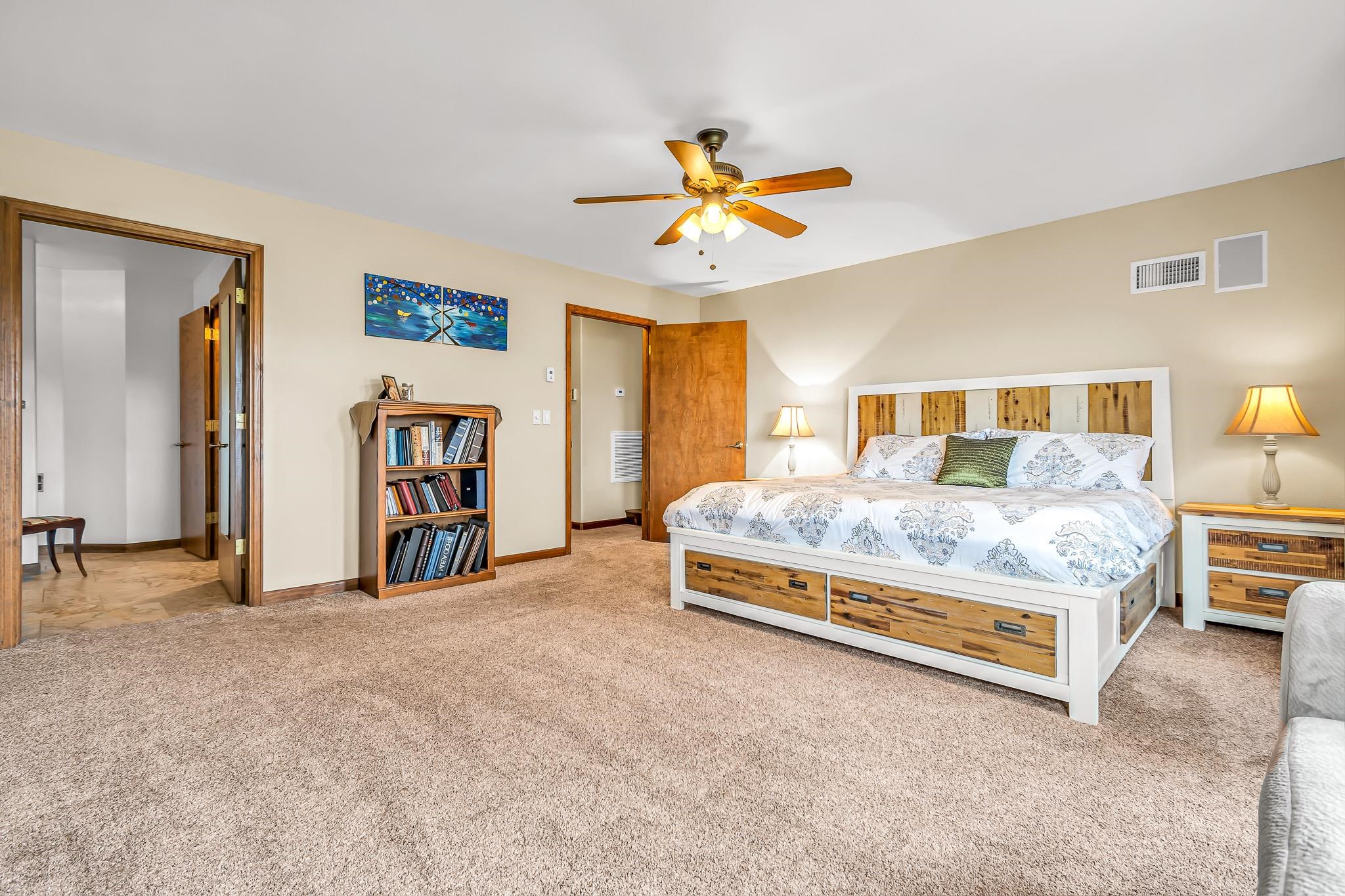 1171 20 Road Fruita, CO 81521 - Photo 15 of 42 a bedroom with a bed and a chandelier