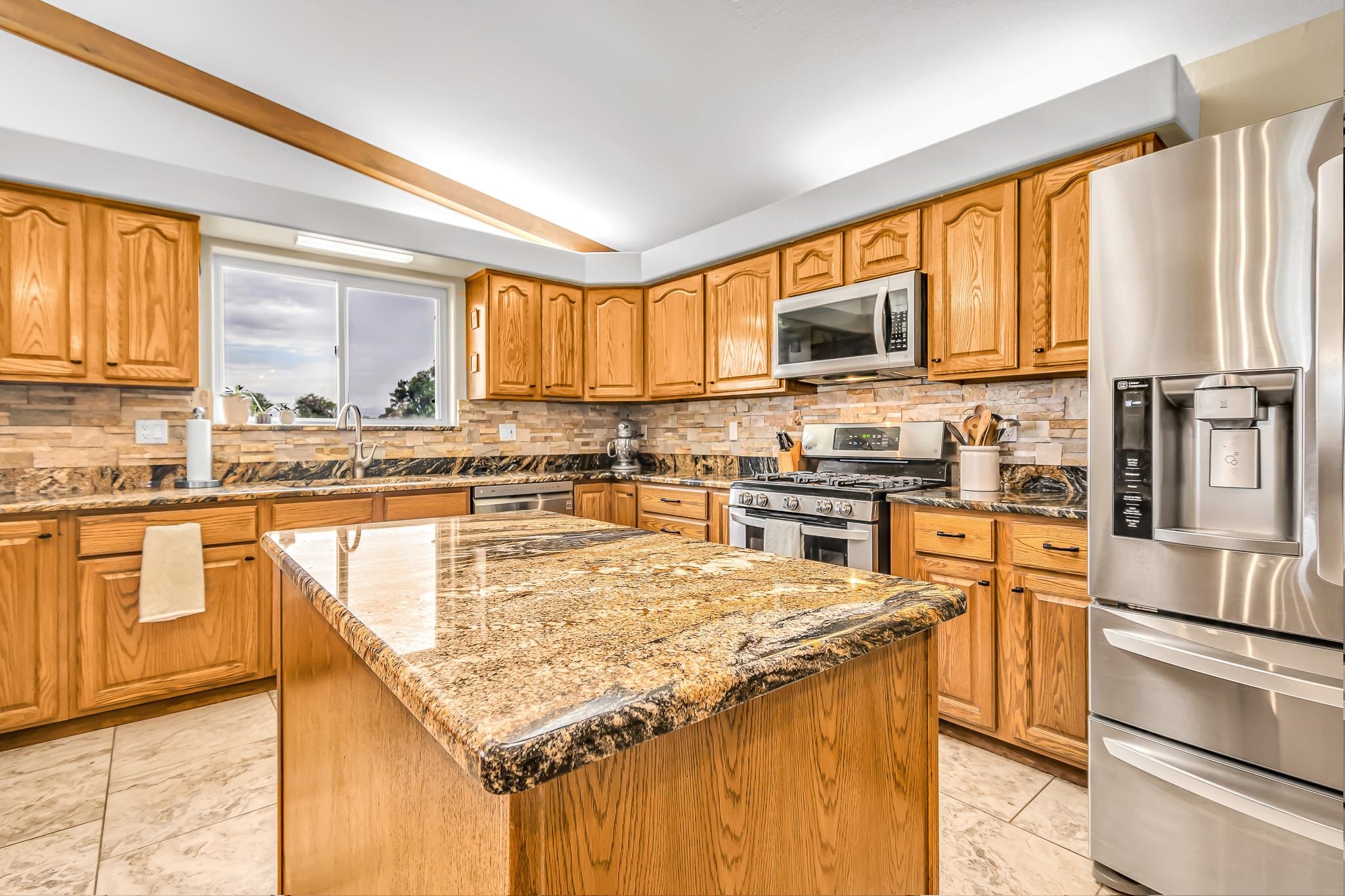1171 20 Road Fruita, CO 81521 - Photo 8 of 42 a kitchen with stainless steel appliances granite countertop a stove a sink and a refrigerator