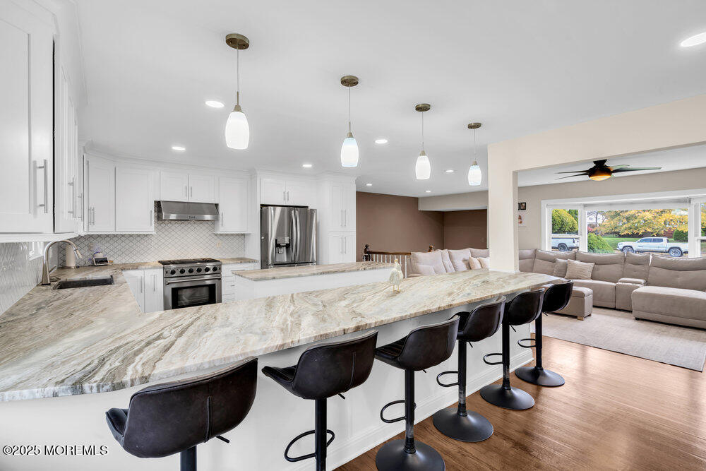 37 Glenbrook Road Freehold, NJ 07728 - Photo 3 of 34 a kitchen with granite countertop a stove a sink a counter space and living room view