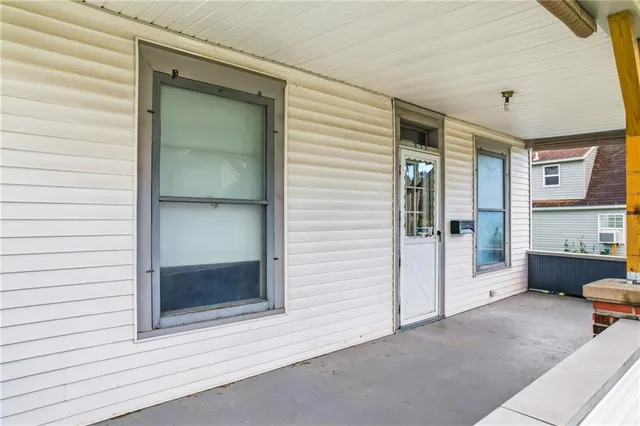 a view of a porch with a door and wooden floor