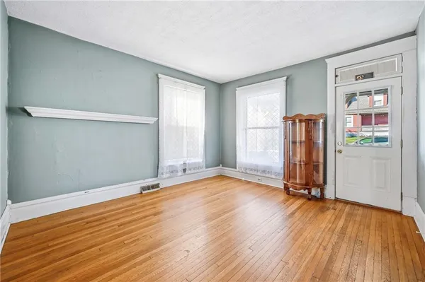 an empty room with wooden floor and a window