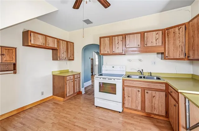 a kitchen with stainless steel appliances granite countertop a stove a sink dishwasher and a refrigerator with wooden cabinets