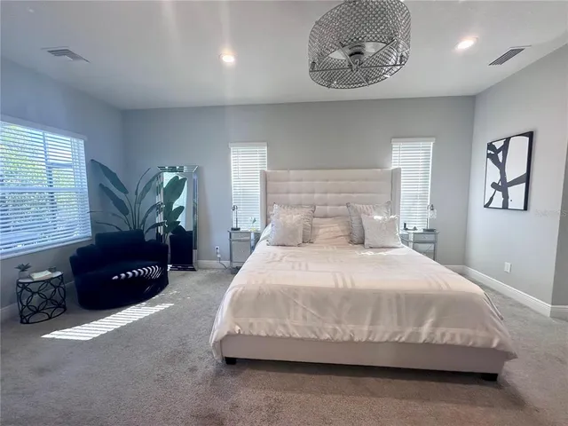 a bedroom with a bed lamp and a window