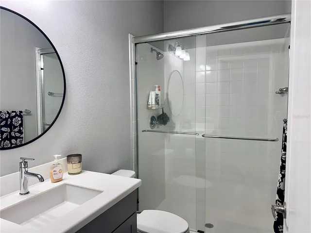 a bathroom with a sink vanity mirror and toilet