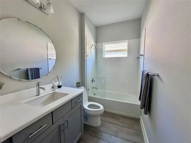 a bathroom with a double vanity sink toilet mirror and shower