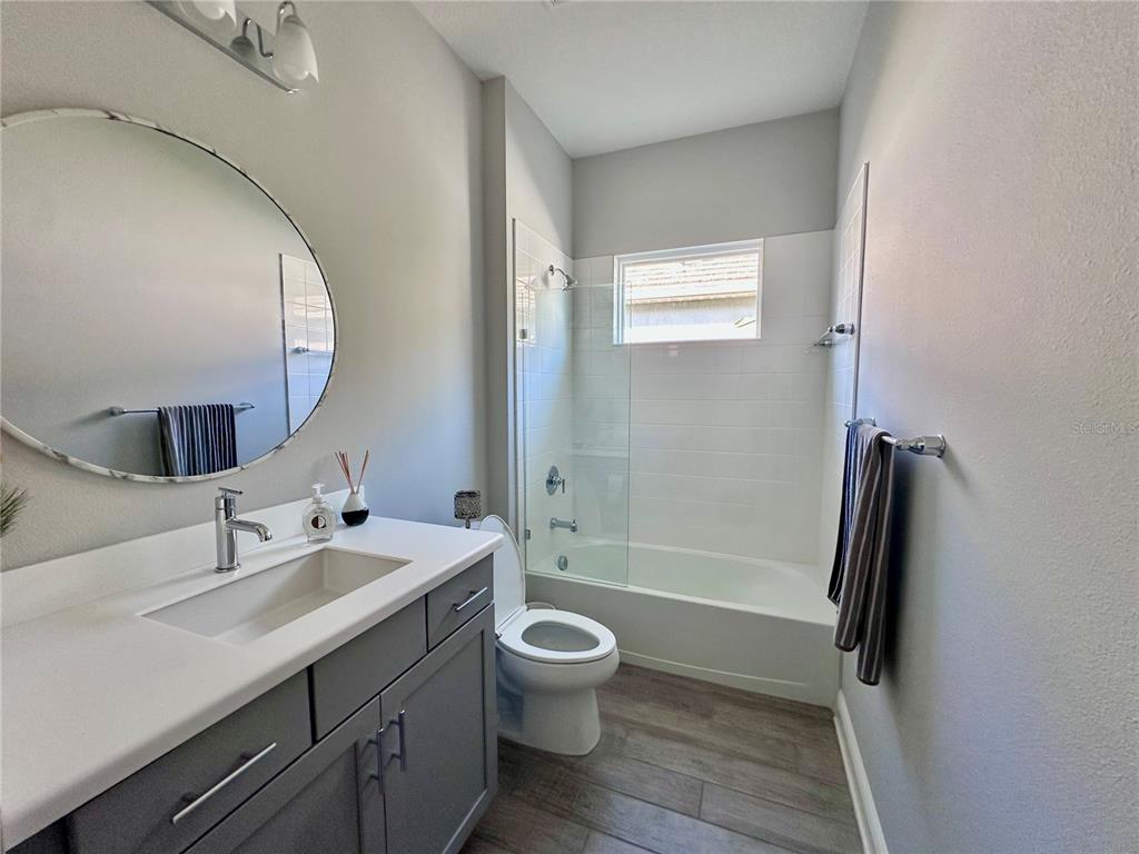 2716 Butterfly Jasmine Trail Sarasota, FL 34240 - Photo 23 of 27 a bathroom with a double vanity sink toilet mirror and shower