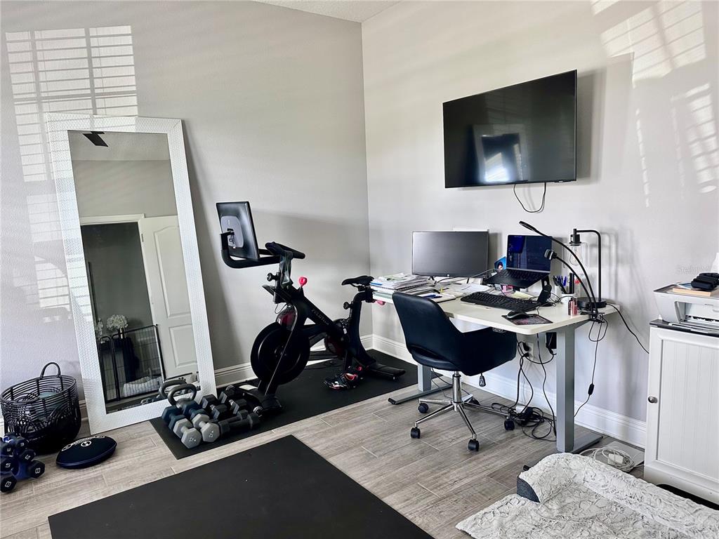 2716 Butterfly Jasmine Trail Sarasota, FL 34240 - Photo 26 of 27 a view of a workspace with furniture and a flat screen tv
