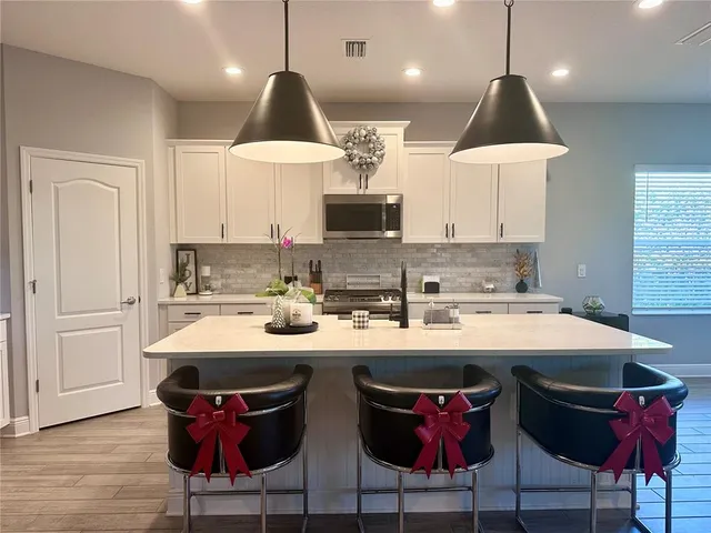 a kitchen with a sink a stove a refrigerator and white cabinets