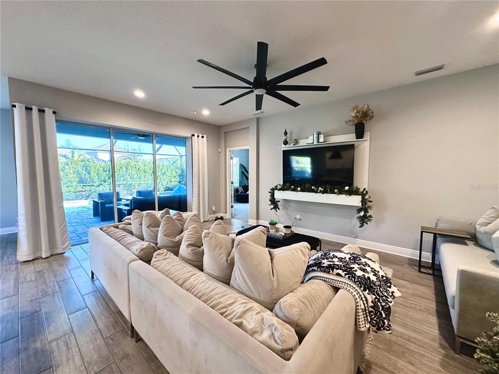 2716 Butterfly Jasmine Trail Sarasota, FL 34240 - Photo 10 of 27 a living room with furniture and a flat screen tv