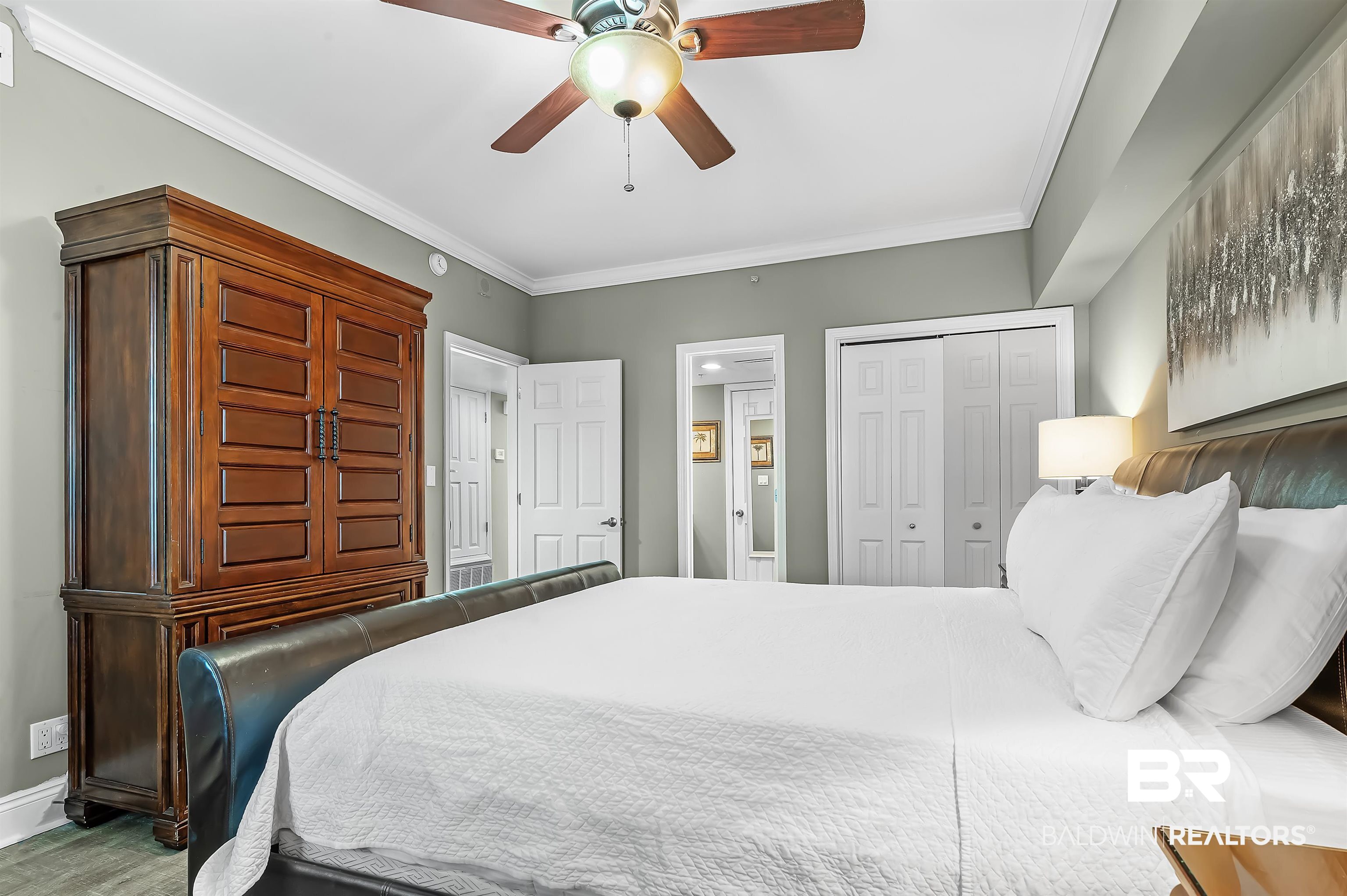 16287 Perdido Key Drive, Unit 105 Pensacola, FL 32507 - Photo 28 of 66 Bedroom featuring crown molding, a ceiling fan with integrated lighting, and multiple entryways