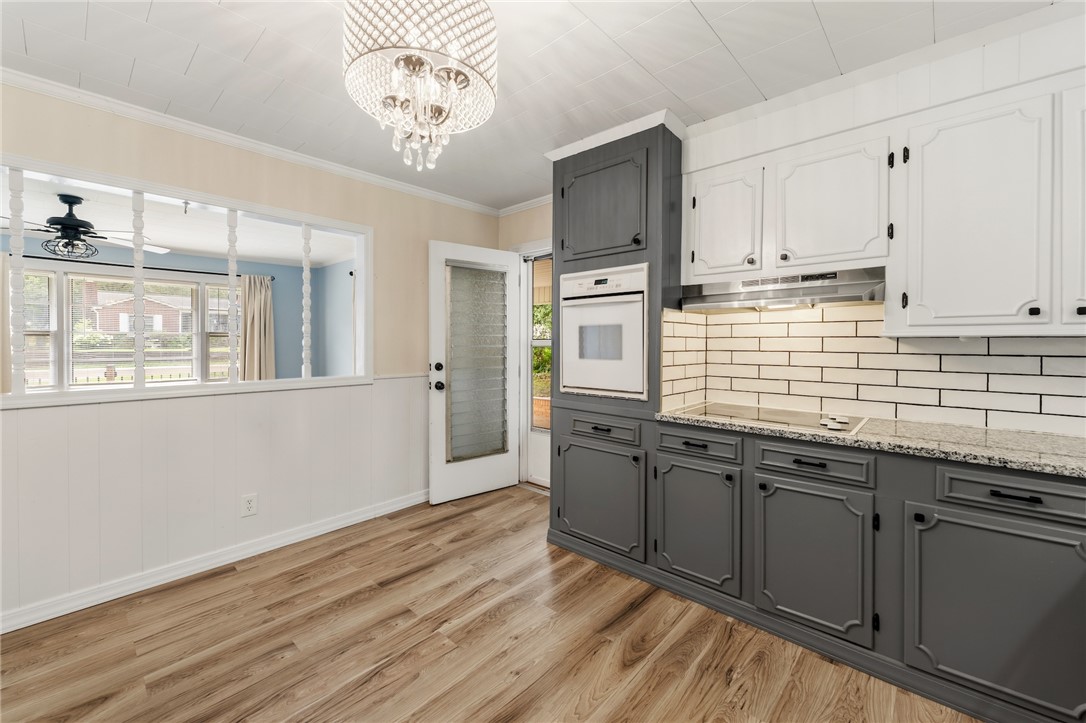 12 Dendy Street Pelzer, SC 29669 - Photo 11 of 31 A built-in electric range oven and modern cooktop adorn this beautifully appointed kitchen, complemented by the elegant wood flooring.