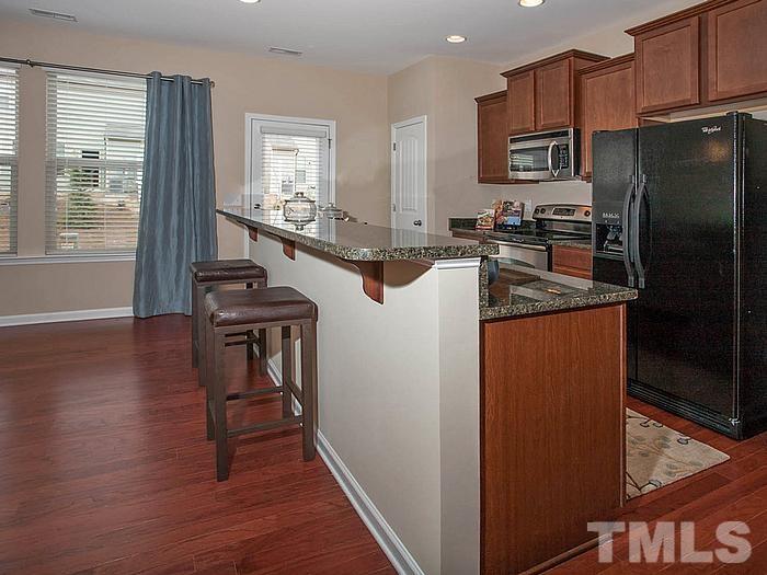 1020 Grand Ridge Drive Rolesville, NC 27571 - Photo 8 of 23 a kitchen with stainless steel appliances granite countertop a refrigerator a stove a sink and a microwave oven with wooden floor
