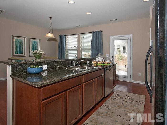 1020 Grand Ridge Drive Rolesville, NC 27571 - Photo 9 of 23 a kitchen with granite countertop a sink and a wooden floor