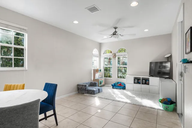 a living room with furniture a flat screen tv and white walls
