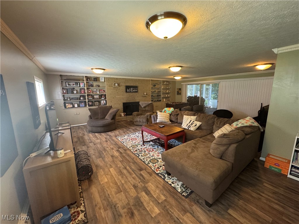 1452 Avalon Road Wooster, OH 44691 - Photo 12 of 31 Living area with wood finished floors, plenty of natural light, a textured ceiling, a brick fireplace, and built in features