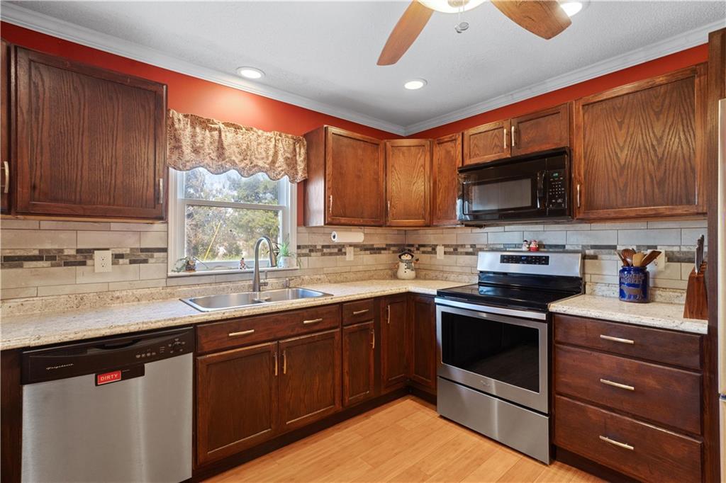 297 Tucker Hollow Road Southeast Calhoun, GA 30701 - Photo 11 of 42 a kitchen with granite countertop a sink stainless steel appliances and cabinets
