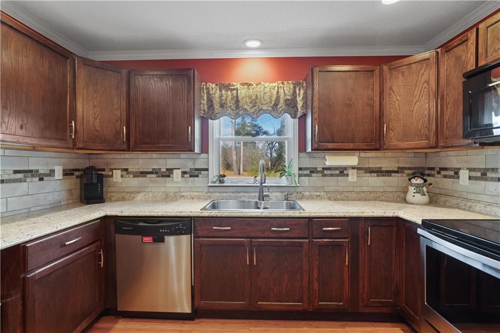 297 Tucker Hollow Road Southeast Calhoun, GA 30701 - Photo 12 of 42 a kitchen with granite countertop a sink cabinets and stainless steel appliances