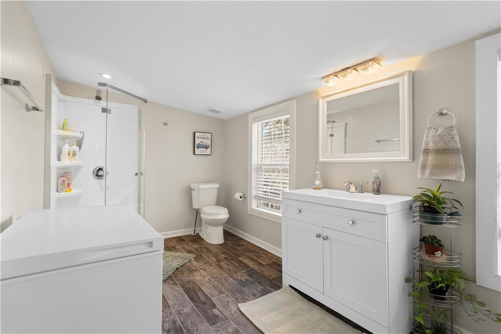 297 Tucker Hollow Road Southeast Calhoun, GA 30701 - Photo 18 of 42 a spacious bathroom with a granite countertop sink a toilet and a mirror