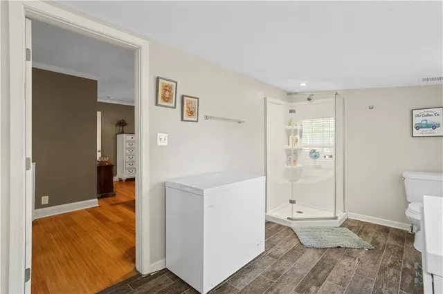 a view of a hallway with bathroom and wooden floor