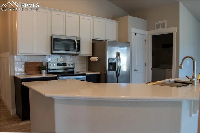 a kitchen with stainless steel appliances a refrigerator sink and microwave