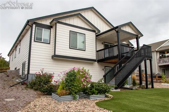 a front view of house along with deck and outdoor seating