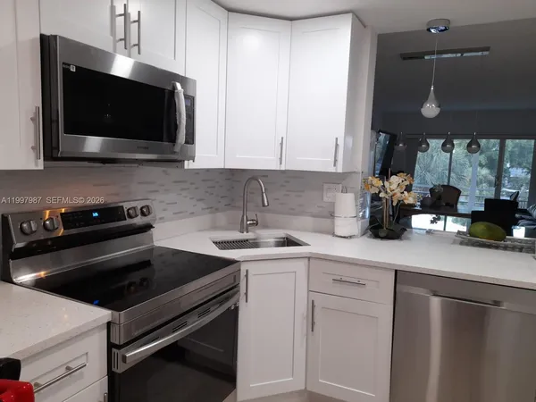 a kitchen with stainless steel appliances a stove a sink and a microwave