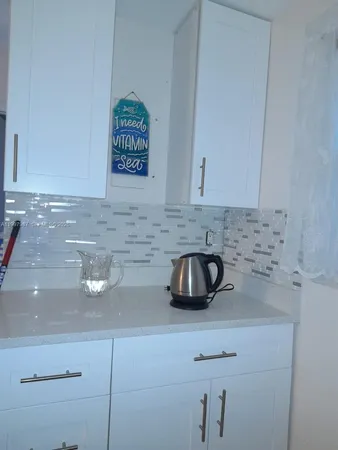 a kitchen with a sink a counter space and cabinets
