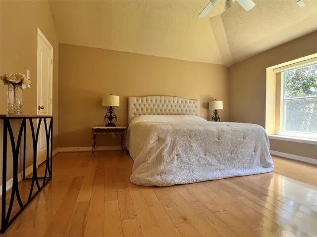 a large bed sitting in a bedroom next to a window