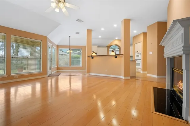 a view of an empty room with a window and wooden floor