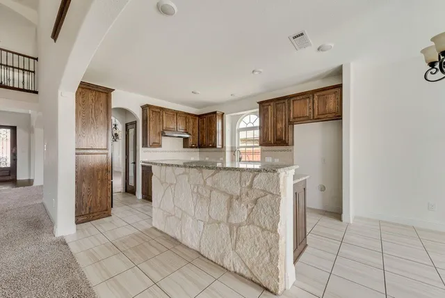 a kitchen with granite countertop a stove and a sink