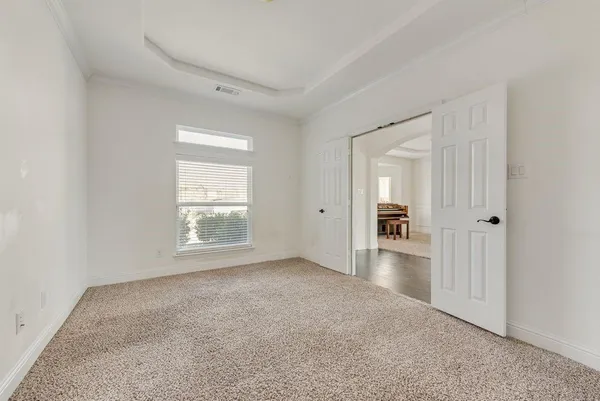 an empty room with windows and ceiling fan