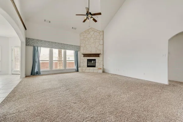 en empty room with windows and fireplace