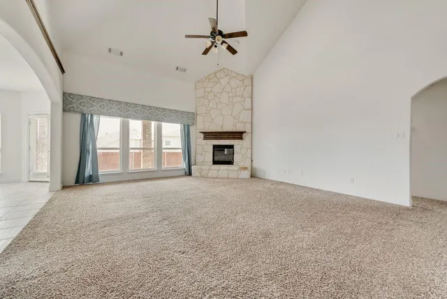 en empty room with windows and fireplace