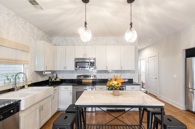 a kitchen with a sink a counter space appliances and cabinets