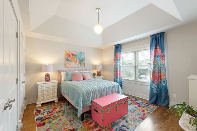 a bedroom with a bed dresser and a window