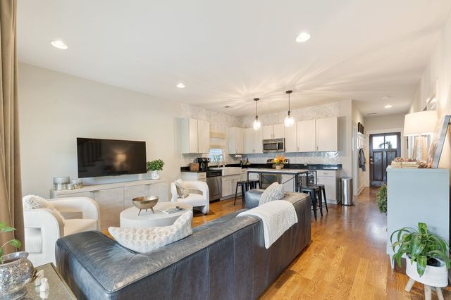 a living room with furniture kitchen view and a flat screen tv