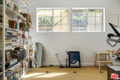 a bedroom with a bed and a potted plant on a dresser