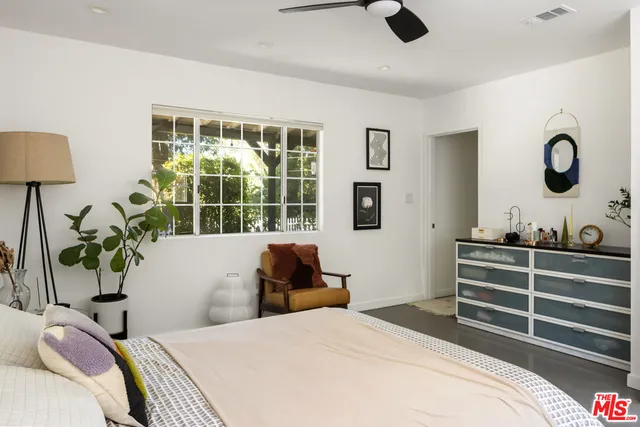 a bedroom with furniture and a large window