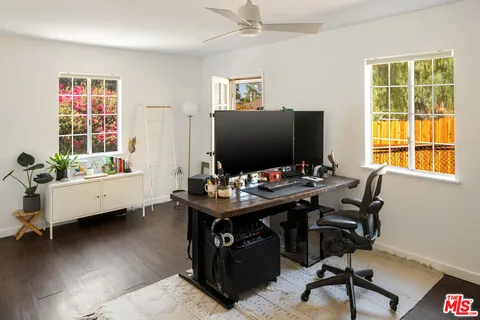 a view of a workspace with furniture and a window