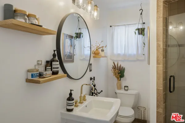 a bathroom with a sink a toilet and a mirror